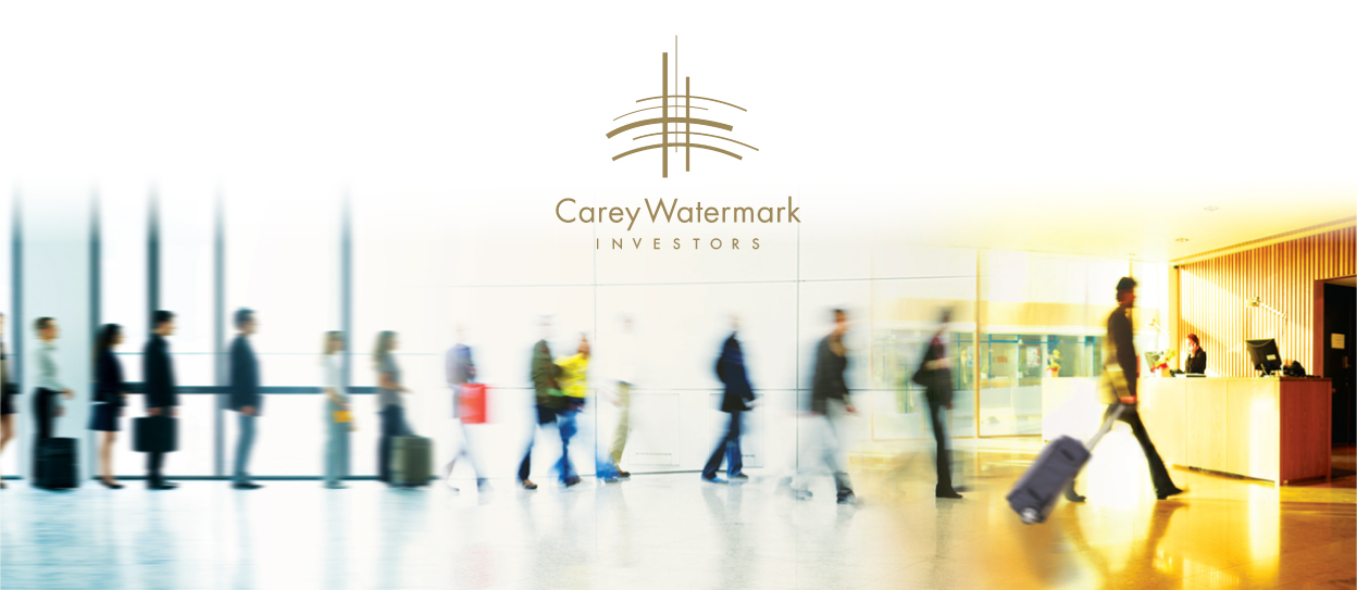 blurred photo of people walking through building with carey watermark logo at the top